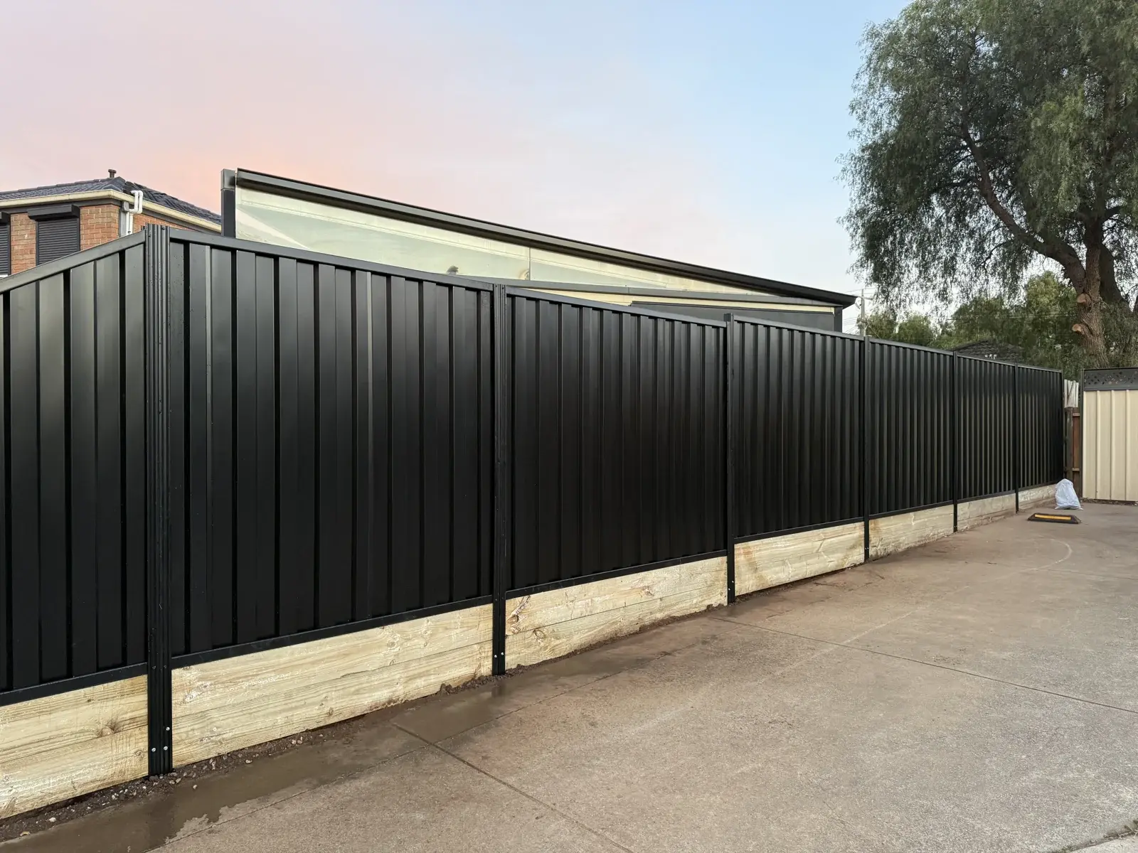 Black boundary timber plinth — APS Pro Fencing