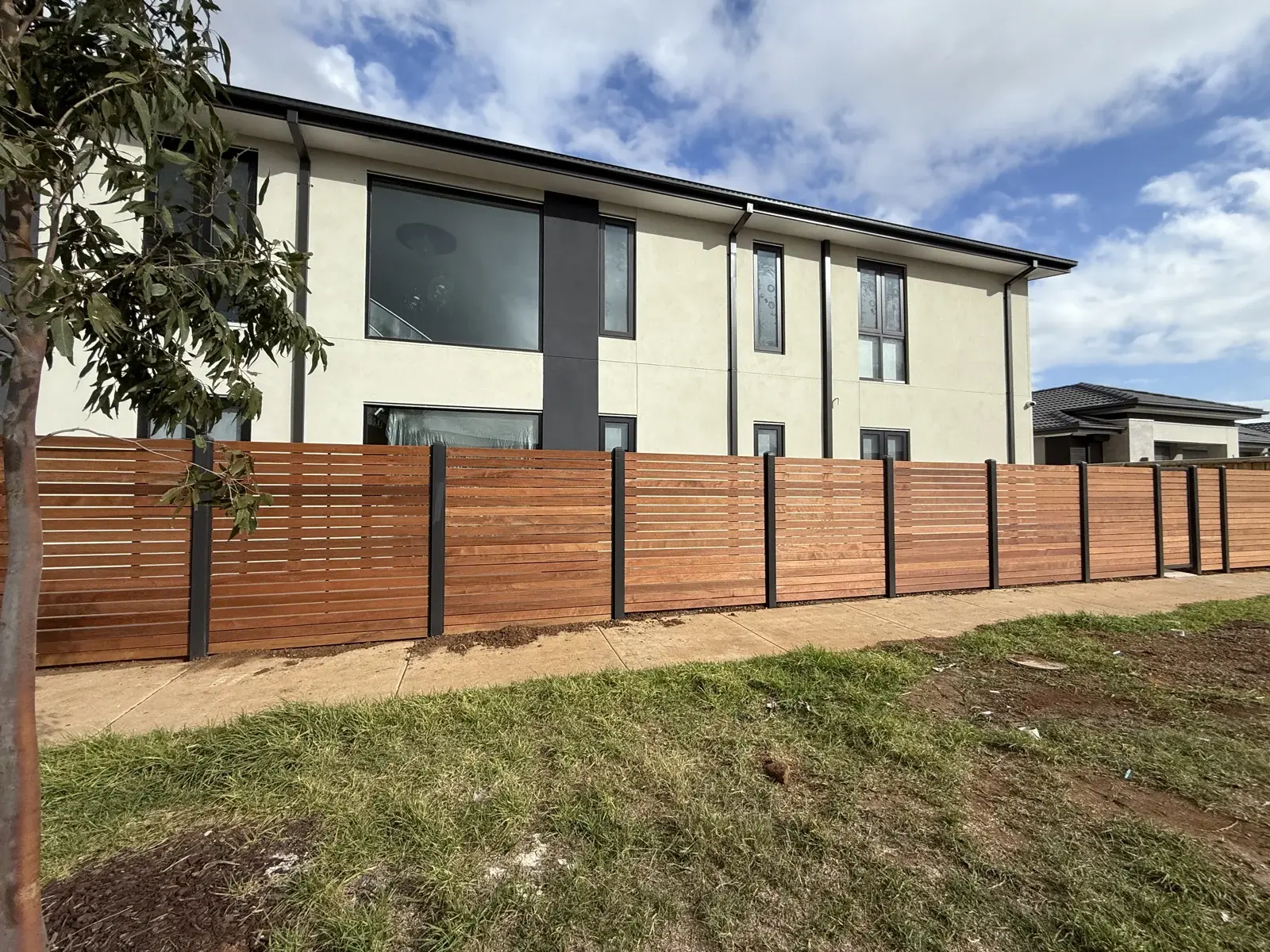 Horizontal timber-look slat fence along a residential front boundary